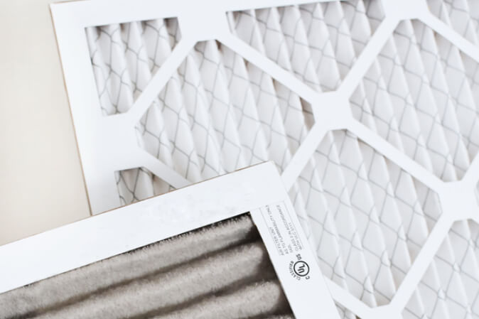 a dirty air filter next to a clean filter